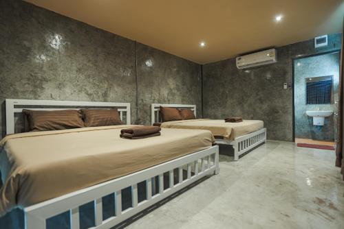 een slaapkamer met 2 bedden en een wastafel bij บ้านภูณิภัทร Beanphuniphat in Nong Prue