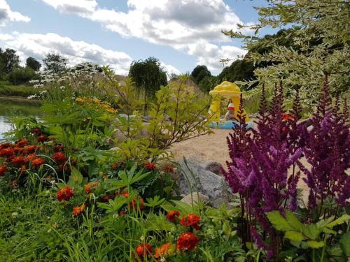 a garden with colorful flowers and a play structure at Liepu Residence in Olayne