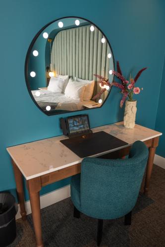 a room with a desk with a mirror and a bed at Van der Valk Hotel Hildesheim in Hildesheim