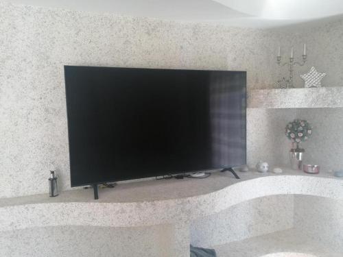 a flat screen tv sitting on a shelf at Liepu Residence in Olayne