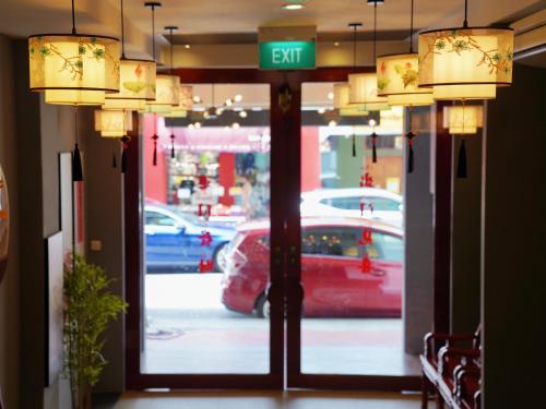 Hotel Calmo Chinatown في سنغافورة: باب لمتجر مع سيارة حمراء بالخارج
