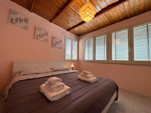 a bedroom with two towels on a bed with windows at Terra mia in Naples