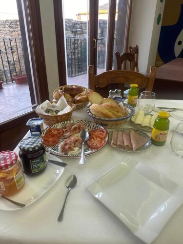 Una mesa con muchos platos de comida encima. en Hospedería Sádaba, en Sádaba