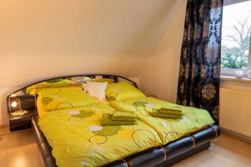 a bedroom with a bed with yellow sheets and a window at Ferienwohnung Sukow in Freest