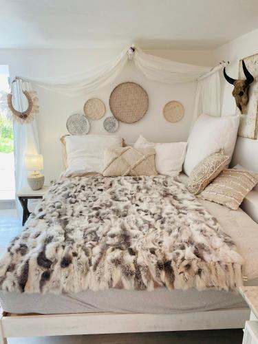 a white bedroom with a large bed with a comforter at Relaxen am Wald in Stephanshausen in Stephanshausen