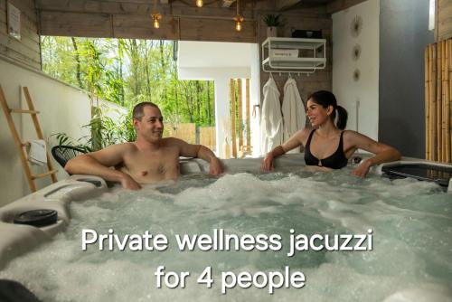 a man and a woman sitting in a hot tub at Happy Island Luxury Apartman Sárvár in Sárvár