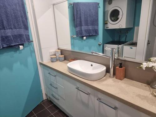 a bathroom with a sink and a mirror at Your Coral Coast Resort Inn in Palm Cove