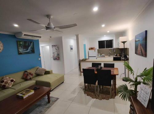 a living room with a couch and a table at Your Coral Coast Resort Inn in Palm Cove