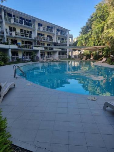 a large swimming pool in front of a building at Your Coral Coast Resort Inn in Palm Cove