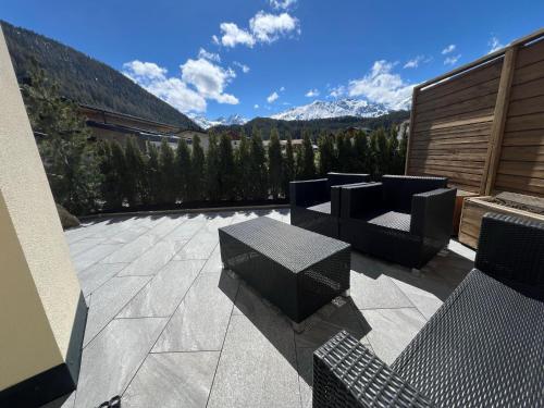 a patio with chairs and a table and mountains at Alp Apart Niederthai in Umhausen