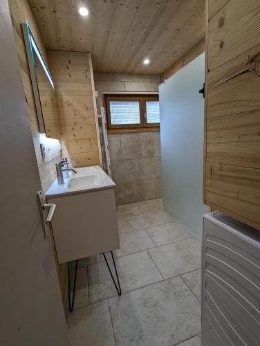 La salle de bains est pourvue d'un lavabo et d'une porte blanche. dans l'établissement Appartement rénové proche centre ville navette 6-8 personnes multipass, à Châtel