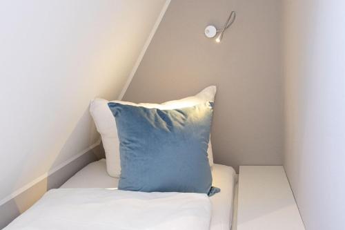 a pillow sitting on a bed in a room at Reethuis-am-Dorfteich-Ferienhaus-Stephanie-02 in Wenningstedt
