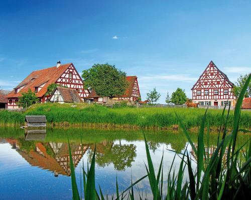 a bench in front of a lake with houses at das windsHEIM Appartements by Vital Hotel 1 und 2 Zimmer Appartements in Bad Windsheim
