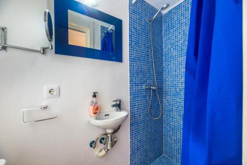 a blue tiled bathroom with a sink and a shower at Can Pep Ramon 2 in Sant Francesc de s'Estany
