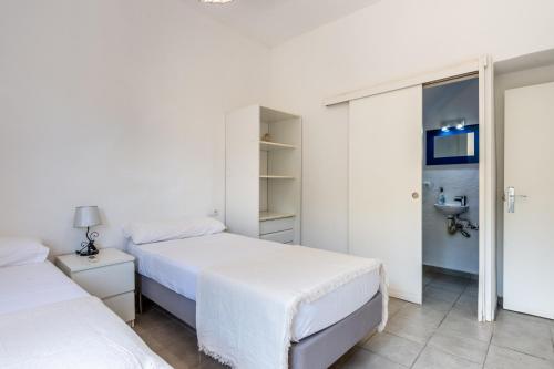two beds in a bedroom with white walls at Can Pep Ramon 2 in Sant Francesc de s'Estany