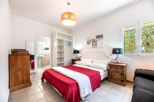 a bedroom with a large bed with a red blanket at Can Pep Ramon 2 in Sant Francesc de s'Estany