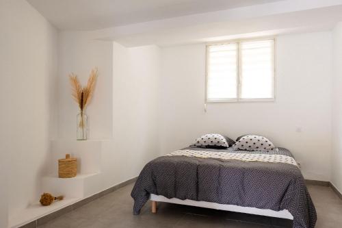 Schlafzimmer mit einem Bett und einem Fenster in der Unterkunft Apparemment départ GR20 in Calenzana