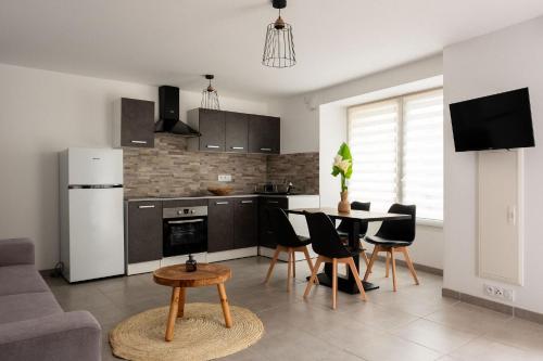 eine Küche und ein Wohnzimmer mit einem Tisch und Stühlen in der Unterkunft Apparemment départ GR20 in Calenzana