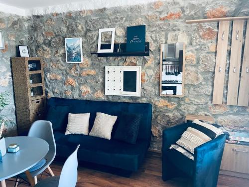 a living room with a blue couch and a table at Kuća za odmor “Dida” in Stinica