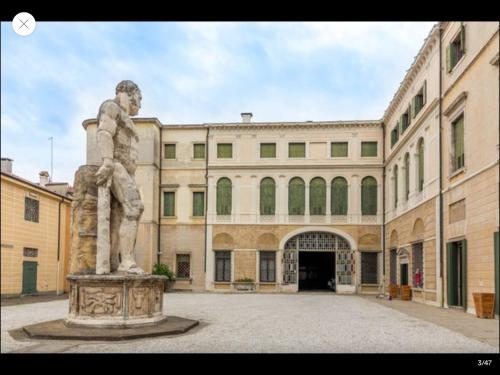 a statue of a man standing in front of a building at Palazzo Mantua Benavides Suites & Apartments in Padova