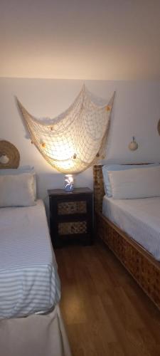 a bedroom with two beds and a net on the wall at Zen Guest House Olistica in Alliste