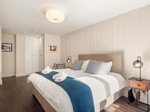 um quarto com uma cama grande com duas toalhas em The Executive at Clifden Boutique Apartments em Clifden