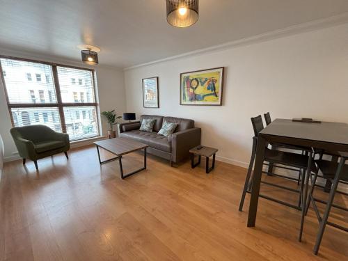 a living room with a couch and a table at Millgrove House Apartments in Eastbourne