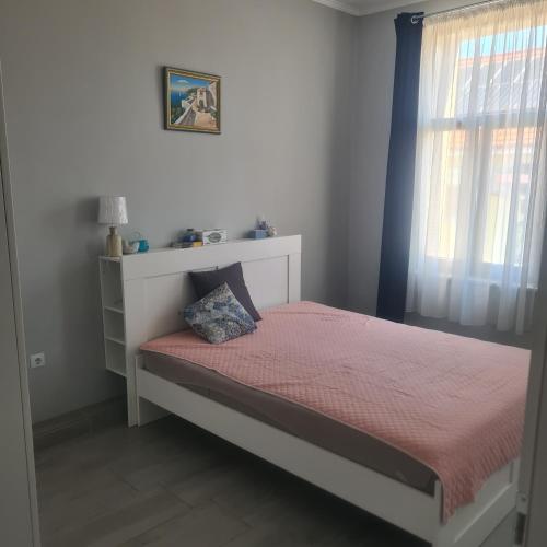 1 dormitorio con 1 cama con manta roja y ventana en Centru Oradea, en Oradea