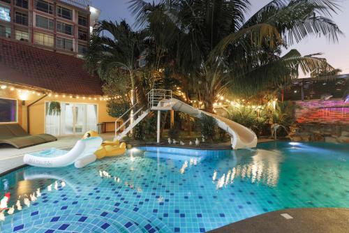 een zwembad met glijbaan in een resort bij บ้านภูณิภัทร Beanphuniphat in Nong Prue