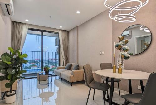 a living room with a couch and a table and a mirror at The Emerald Golf View in Thuan An