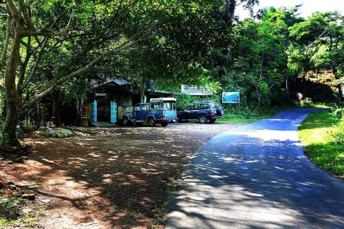 a road with two cars parked next to a house at Jayanta Hotel in Chittagong
