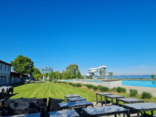 a row of picnic tables next to a swimming pool at Herberge-Unterkunft-Seeperle in Rorschach in Rorschach