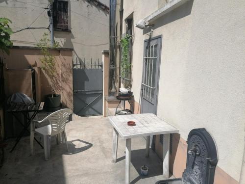 a patio with a table and chairs next to a building at Cozy Polo's House in Bagnolet