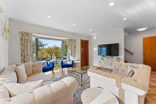 a living room with two white couches and a television at Not usually available – Lucky U! in Auckland