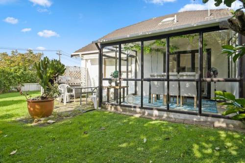 a conservatory with glass doors on a house at Not usually available – Lucky U! in Auckland