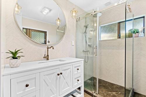 a bathroom with a shower and a sink and a mirror at Not usually available – Lucky U! in Auckland