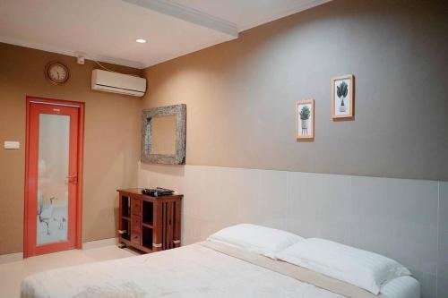 - une chambre avec un lit et une horloge murale dans l'établissement Warm Pool Mt Villa Teras Teduh, à Karangtengah
