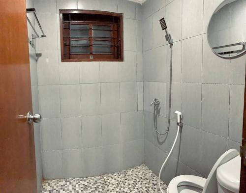 La salle de bains est pourvue d'une douche, de toilettes et d'une fenêtre. dans l'établissement Warm Pool Mt Villa Teras Teduh, à Karangtengah