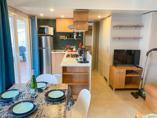 a small kitchen with a table and chairs in a room at Mobil-home CAMARGUE in Vias