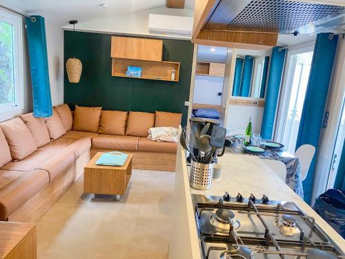 a living room with a couch and a stove at Mobil-home CAMARGUE in Vias