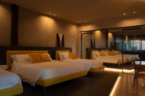 Habitación de hotel con 3 camas con almohadas amarillas en Spera Luxury, en Monreale