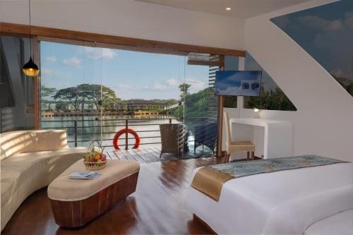 a bedroom with a bed and a balcony with a tv at Bolagala Agro Floating Resort in Negombo