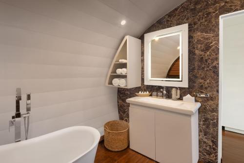 een badkamer met een witte wastafel en een spiegel bij Bolagala Agro Floating Resort in Negombo