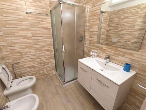 y baño con aseo, lavabo y ducha. en Jet Residence Agenzia Riviera del Conero, en Porto Recanati