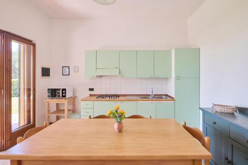 una cucina con tavolo in legno e vaso di fiori di Mare Etrusco Villetta D1 a Populonia