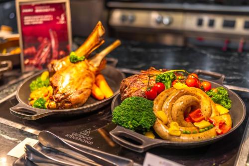 two plates of food on a table with meat and vegetables at Shangri-La Wuhan,Close to The Mixc with three subway lines in Wuhan