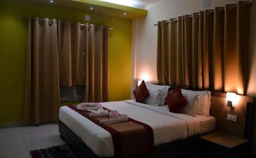 a bedroom with a large bed with yellow walls at Liberty Resort in Puri