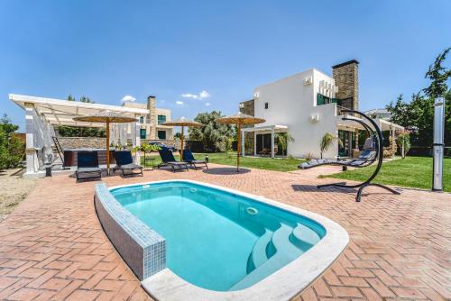 una piscina en un patio con una casa en Heliophos Villa Amalthia, en Kiotari