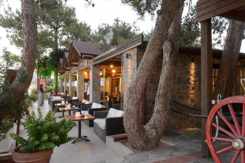 a building with trees and tables and chairs at Alexander Beach Hotel & Village Resort in Malia