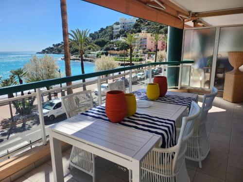 un tavolo e sedie su un balcone con vista sull'oceano di Annabel's Suite Apartament a Roquebrune-Cap-Martin